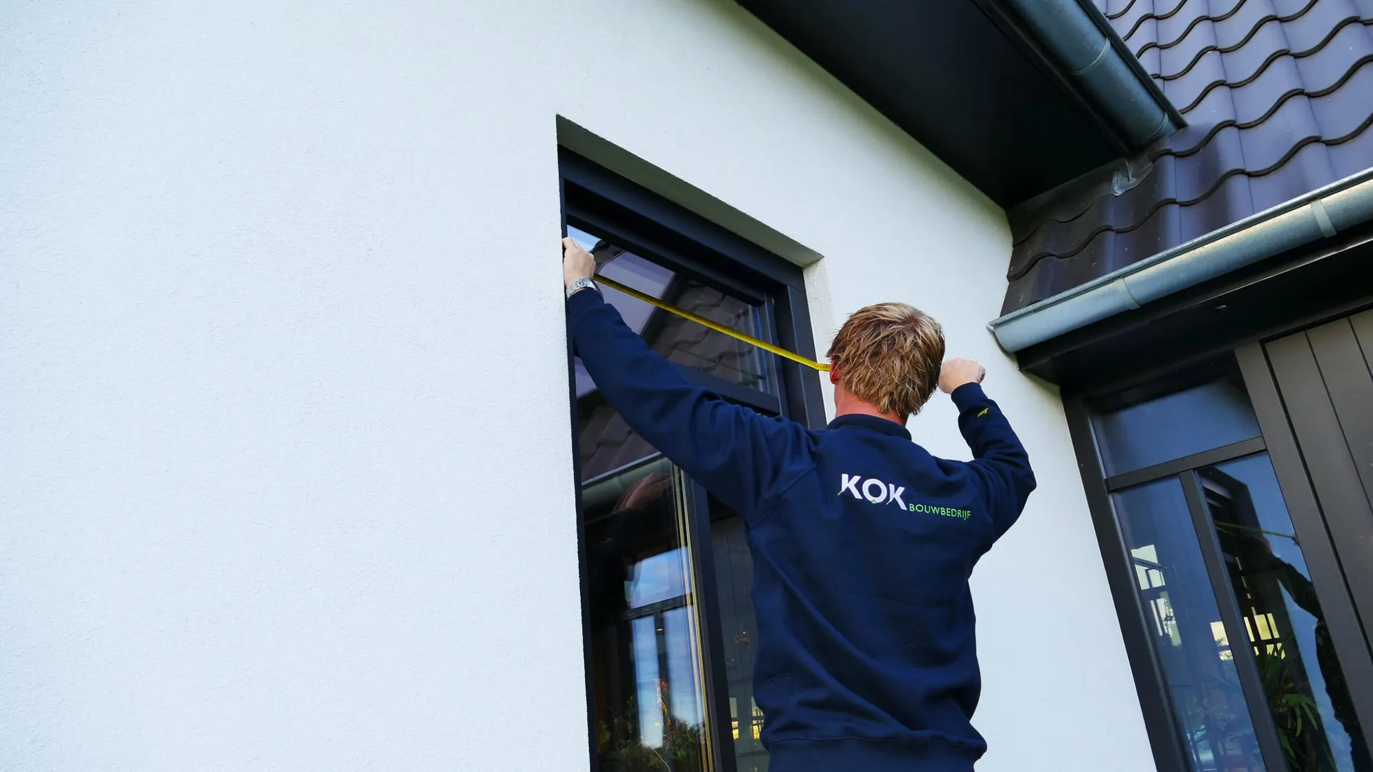 Timmerman van Bouwbedrijf Kok meet een kozijn in op de bouwplaats